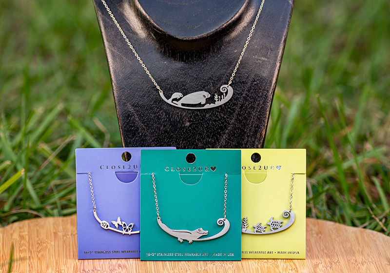 three necklaces on colorful cards one displayed on a neckform
