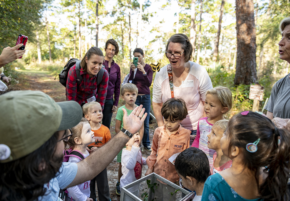 butterfly being released with children and adults watching