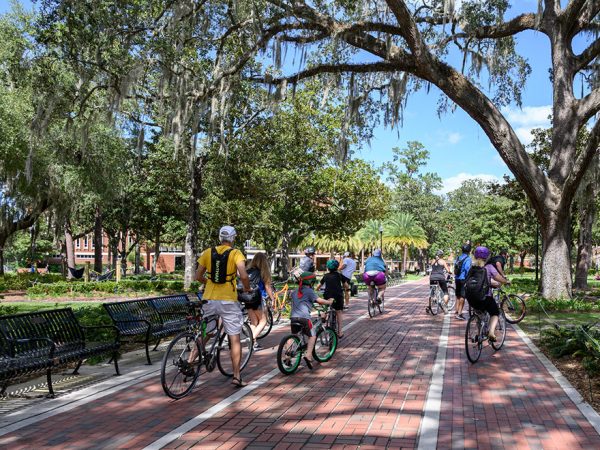 group of people on bicycles riding on a university campus