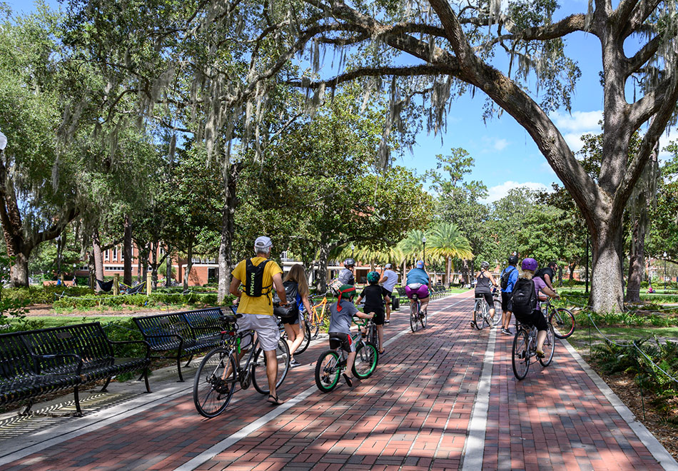 group of people on bicycles riding on a university campus