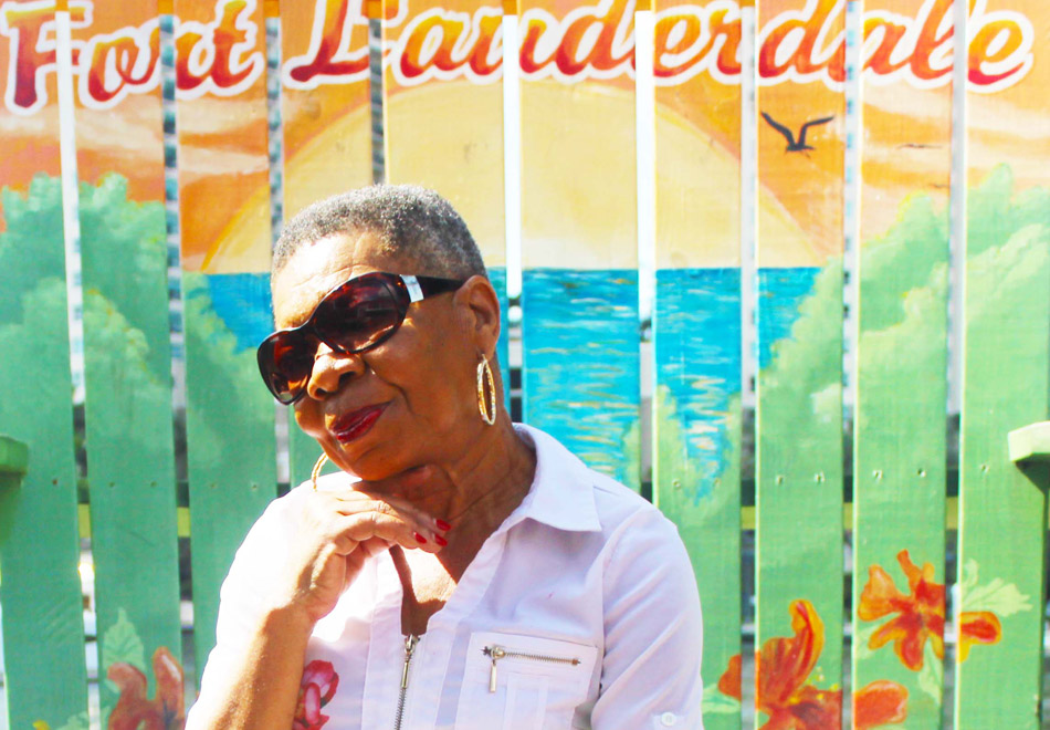 woman smiling at camera in front of a brightly colored background