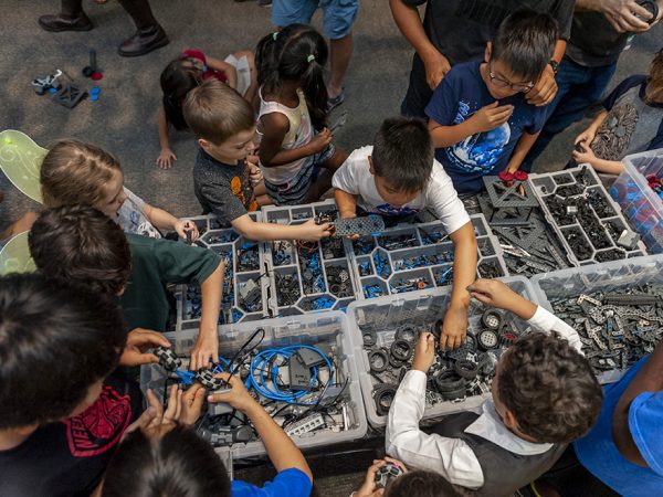children looking over boxes of objects