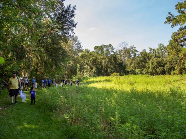 group of adults and children walking around a path at the edge of a field