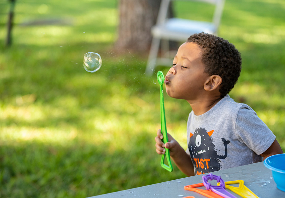 young child blowing bubbles