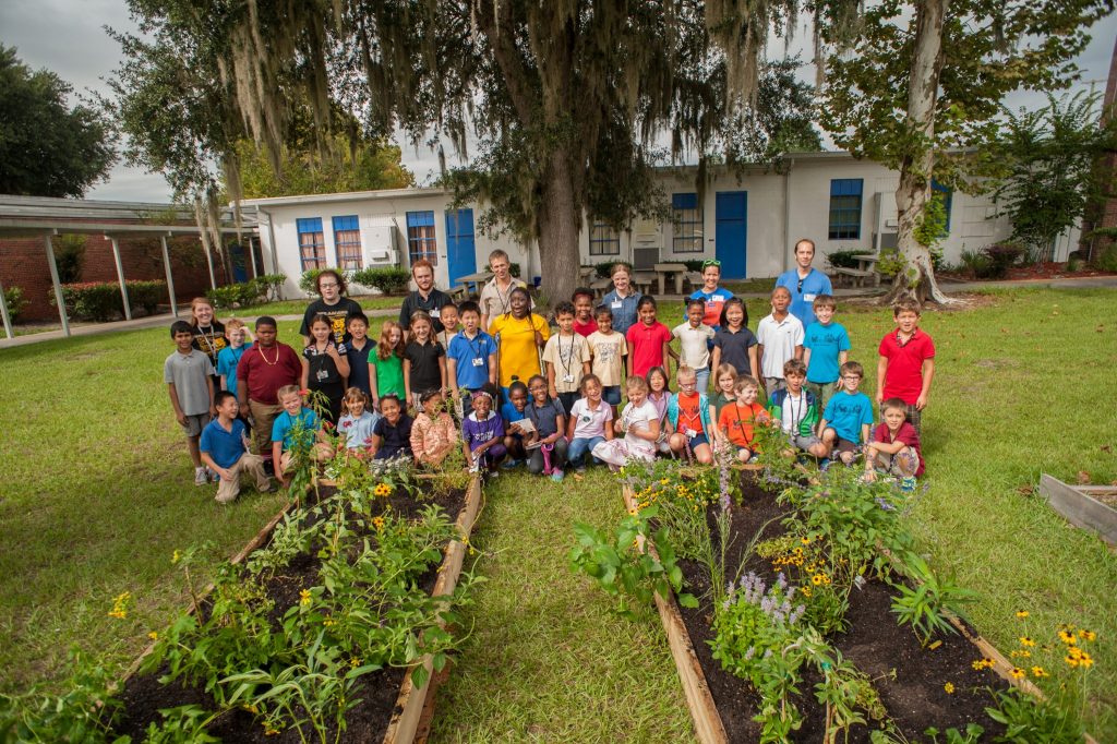 group photo of children with freshly planted butterfly gardens