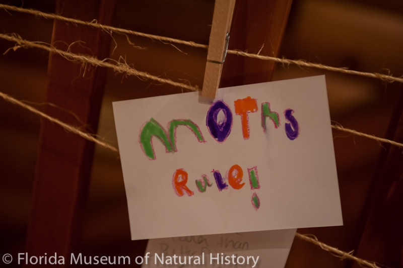 sign with the words "moths rule!" written in crayon