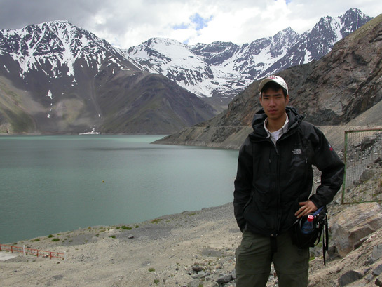 scientist standing in front of a mountain lake