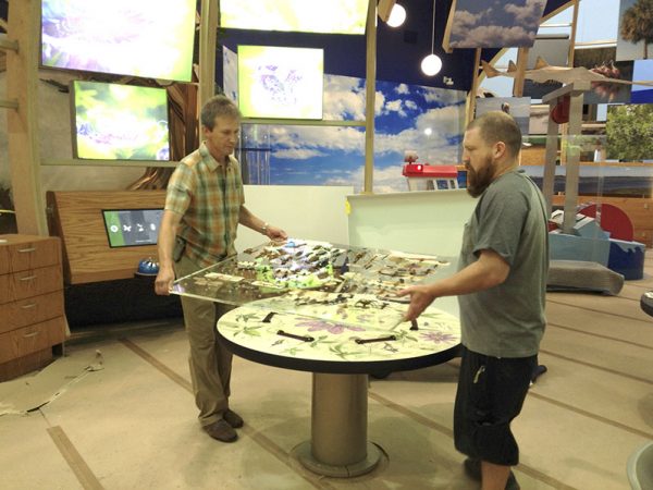 two people carrying the plexiglass
