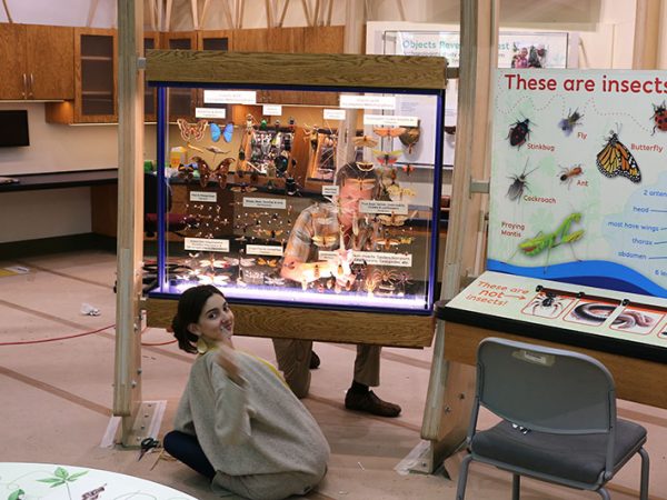 two people carefully cleaning display