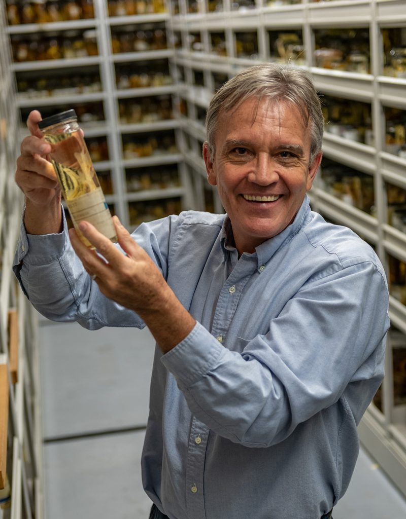 Gavin Naylor holding a specimen jar in the fish collection
