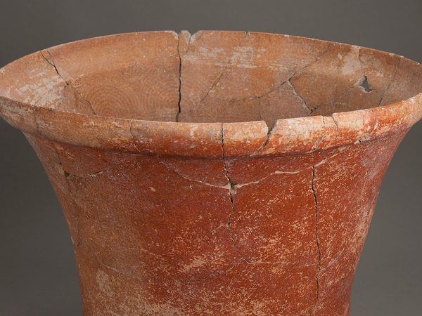 Terra-cotta colored pot with a curved lip and a faint circular pattern visible on the interior. Fine cracks can be seem where the bucket was reassembled