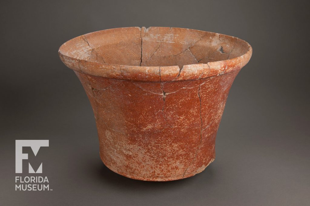 Terra-cotta colored pot with a curved lip and a faint circular pattern visible on the interior. Fine cracks can be seem where the bucket was reassembled