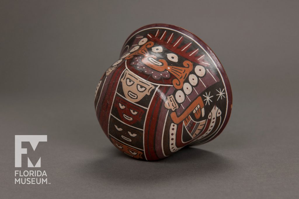 bowl painted with several figure in black, orange, purple, red, and tan. The bowl is turned on it s side to show the painted figures on the bottom of the bowl