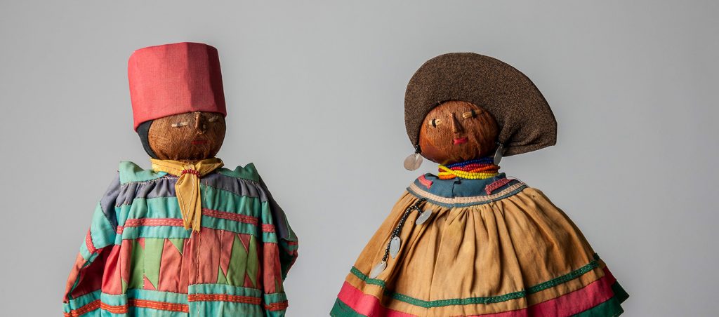 close up of two dolls dress in bright clothing