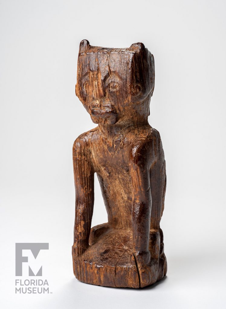 Carved wooden figurine with well-defined facial features, torso, and arms