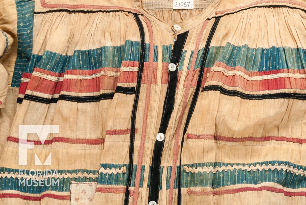 Close up of a Man’s Long Shirt sewn from faded tan, blue, red and black fabric