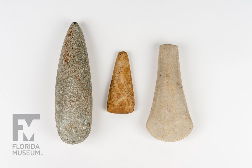 three stone hoes of various sizes, shapes, and color, Each is long with a rounded base and sharper tip