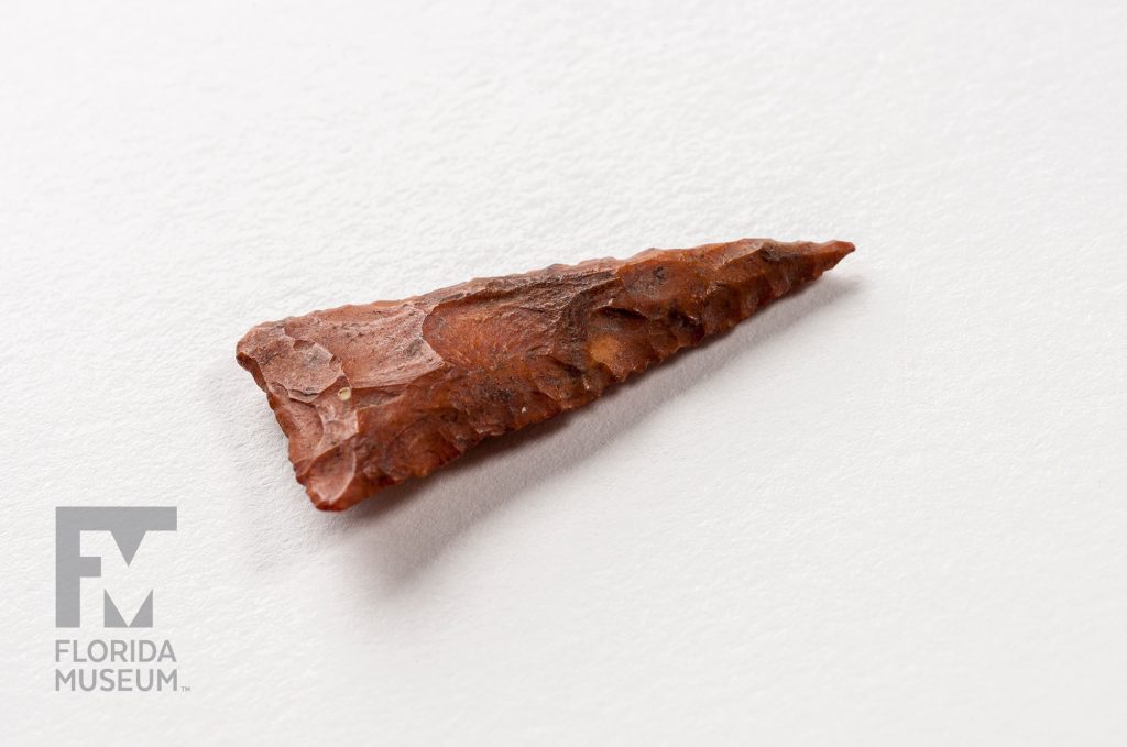 red stone carved into a long triangle with a sharp point