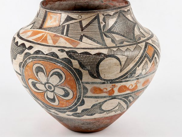 vase painted with tan, black and Terra-cotta colored flowers, birds, and geometric patterns.