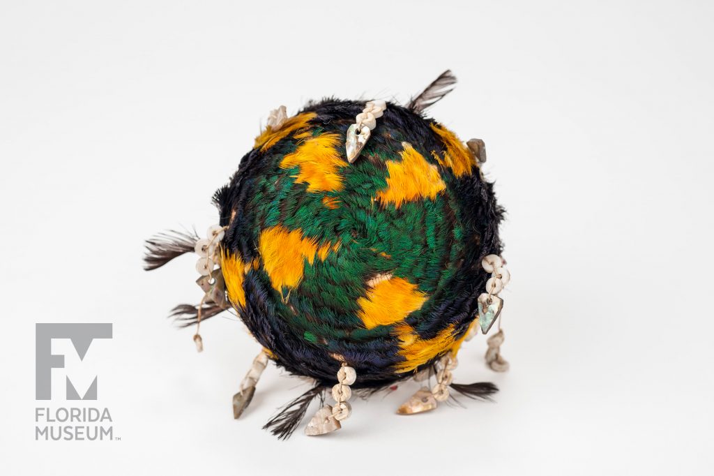 bottom of the coiled basket showing the pattern created with green and yellow feathers