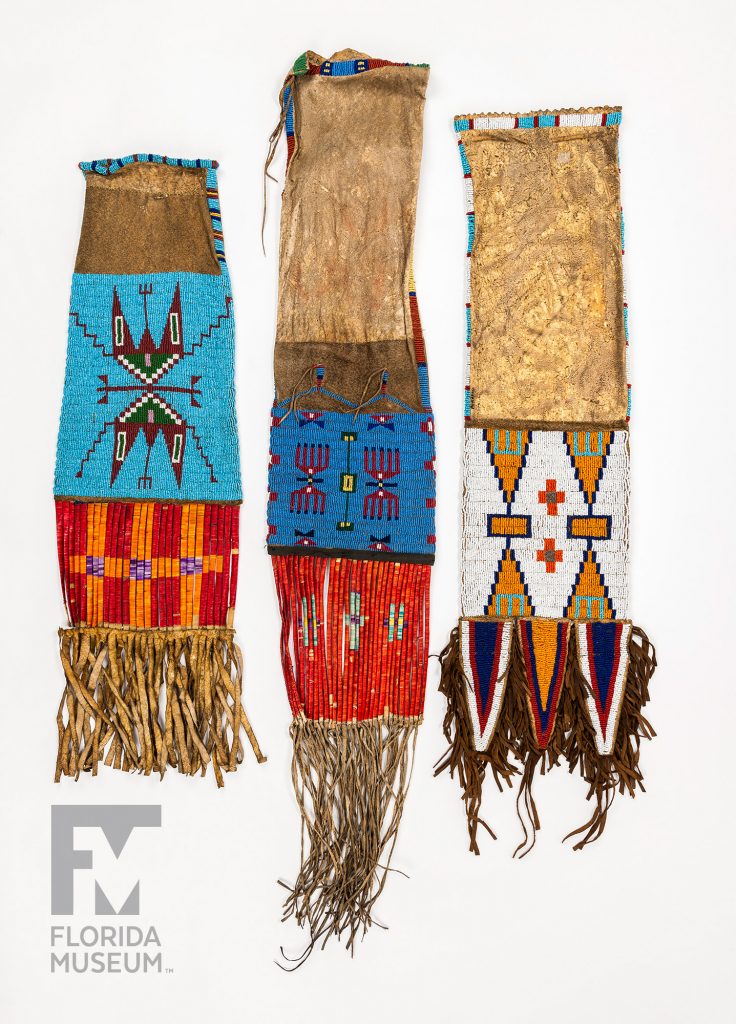 three pouches with colorful quill work and long leather and bead fringe
