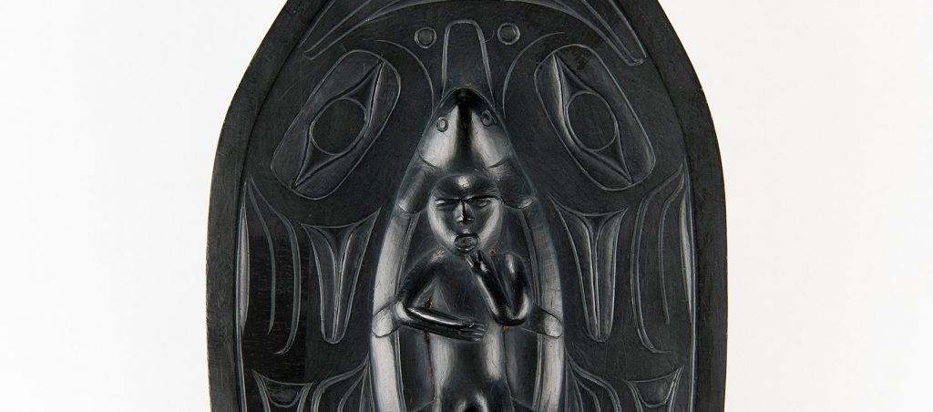 carving of a figure at the center of the platter