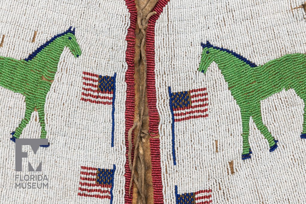 heavily beaded vest with a design of green horses and American flags