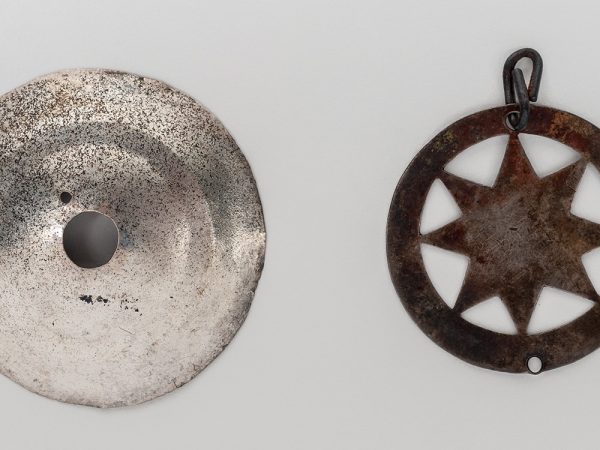 Two Metal Ornaments one is star shaped with a loop for a necklace or string, the other is a disk with a hole at the center