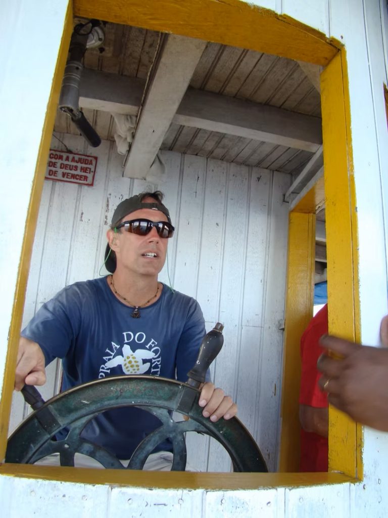 person at the helm of a boat