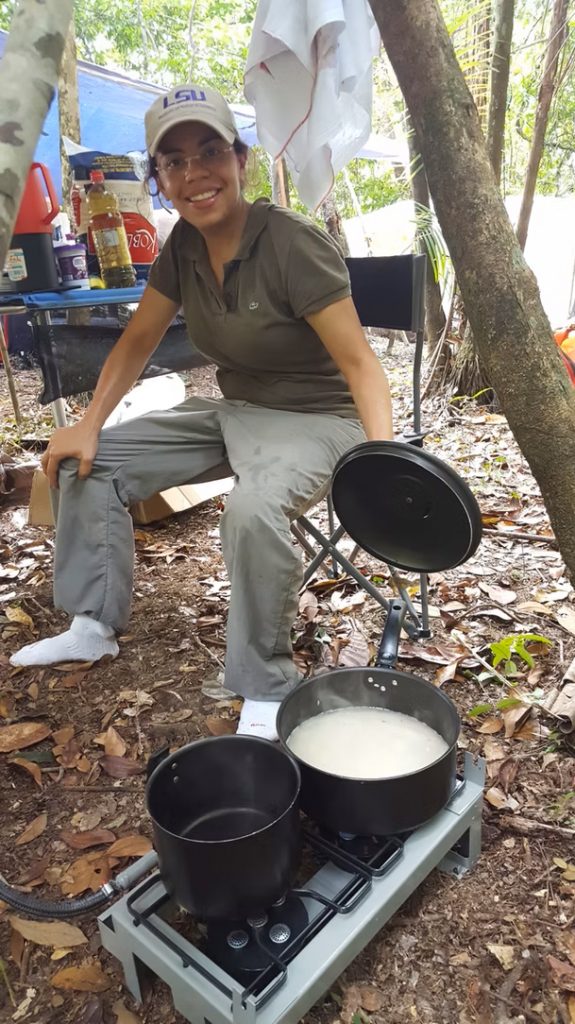 Glaucia Del-Rio cooking on a camp stove