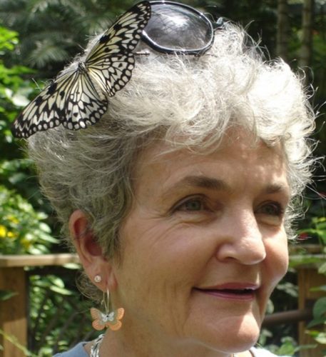 Virginia Dolder, museum volunteer, smiles with a butterfly in her hair.