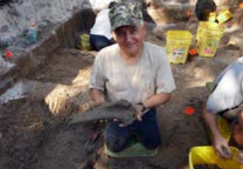 George holding a partial Bison leg bone he excavated while volunteering with the Florida Museum of Natural History. Photo courtesy of George Martin