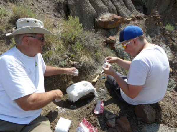 Dinosaur Research Institute president Al Rasmuson coaches Christian Kiss in jacketing skills.
