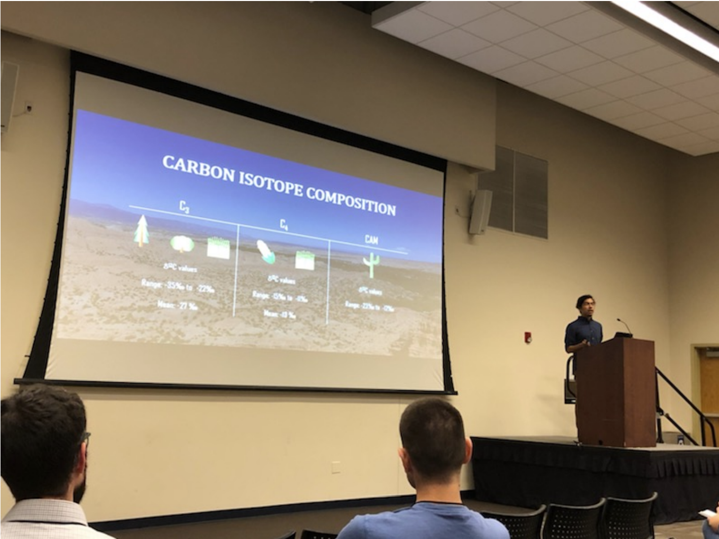 Isaac explaining the different photosynthetic pathways that plants use during cellular respiration and the factors that influence this process during his research presentation.