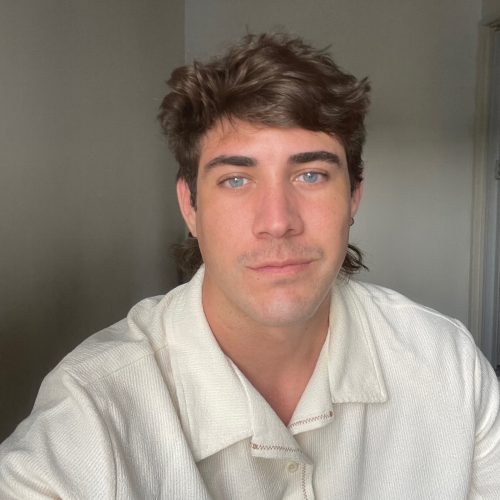 A person wearing a white shirt looking into the camera.