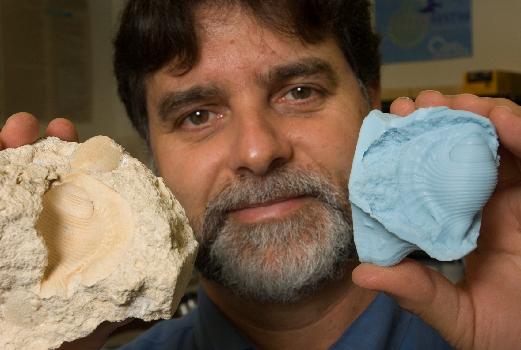 man holding fossil and fossil mold