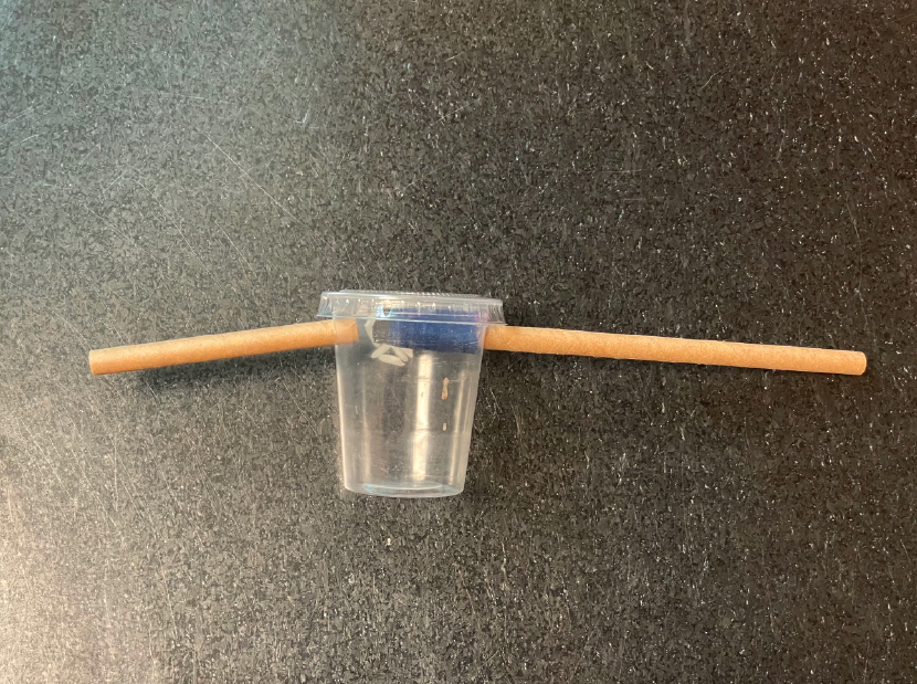 plastic cup with two strays cut into the sides