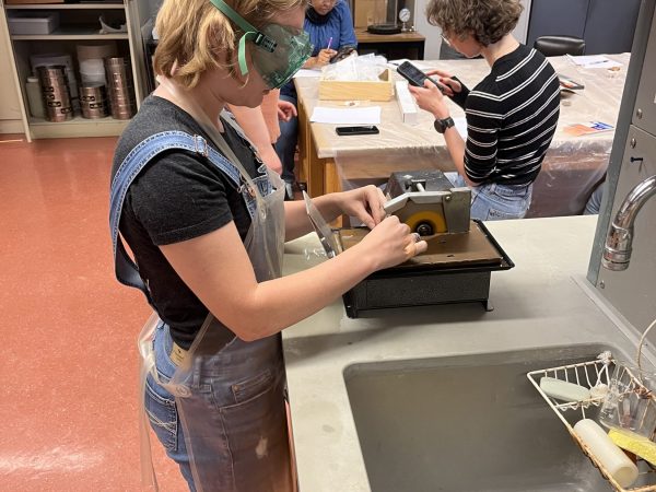 Gloria Church using a saw to cut ceramic samples into a thin section slide