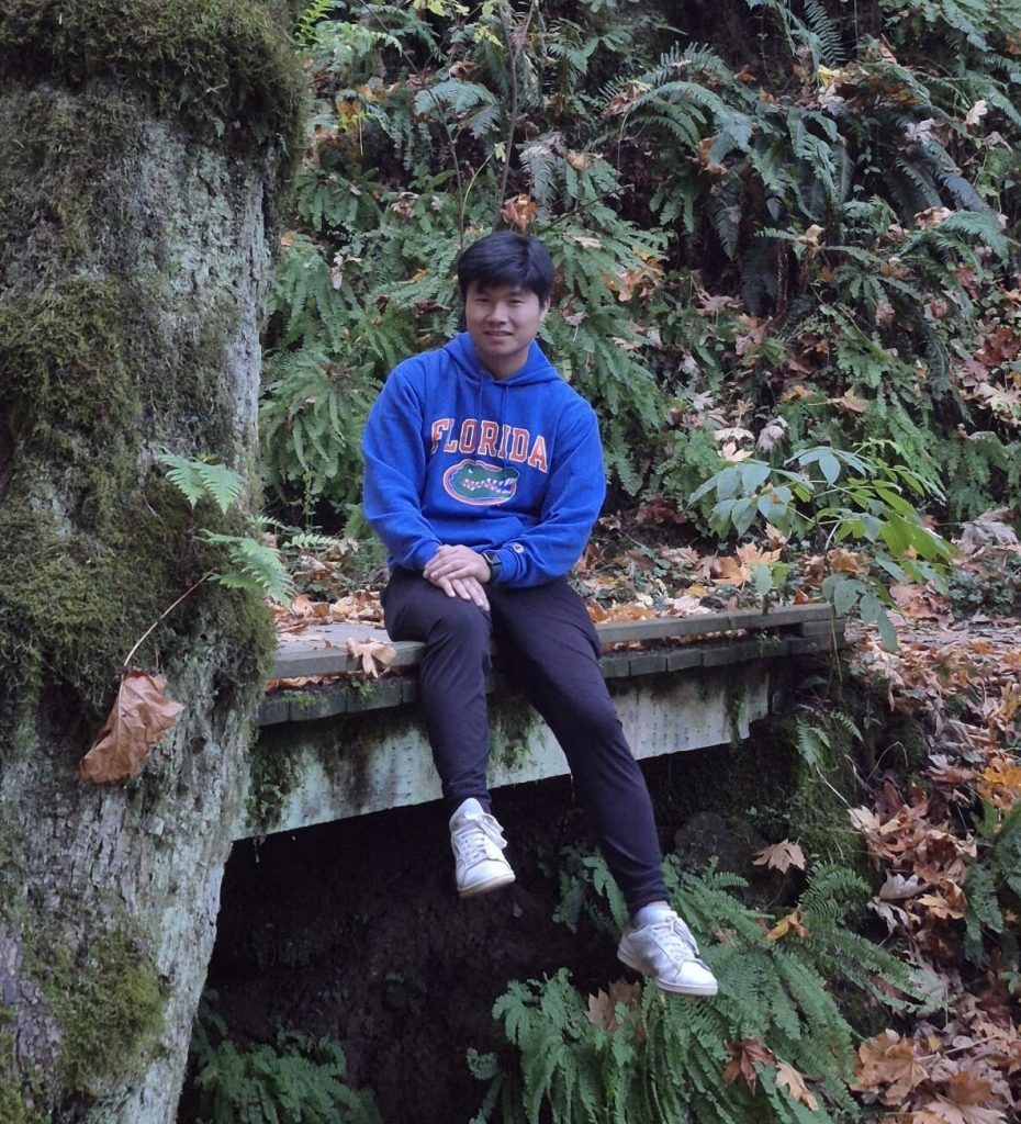 Andrew Hong at sitting surrounded by greenery at Forest Park in Portland, Oregon