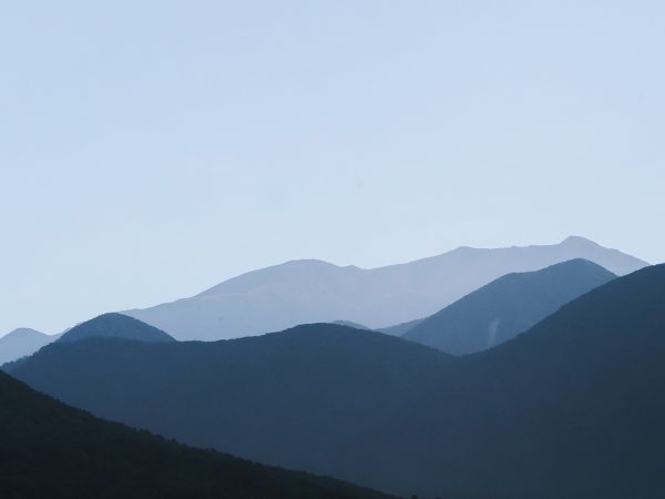 shadowed mountain range against light sky