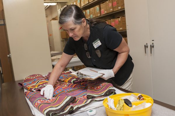 Karen Walker inspects a Seminole longshirt