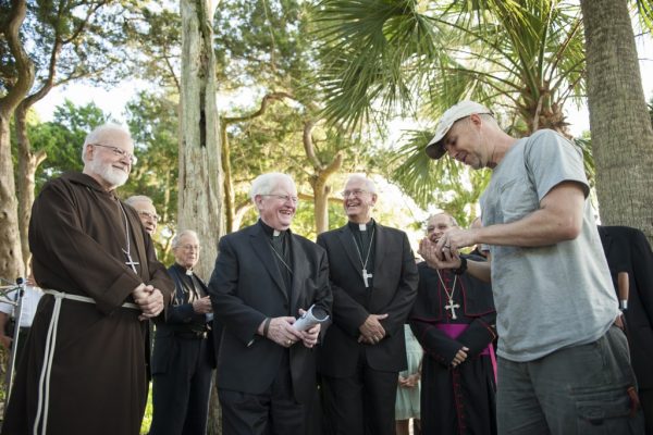 Waters shows a newly found artifact to a group of priests