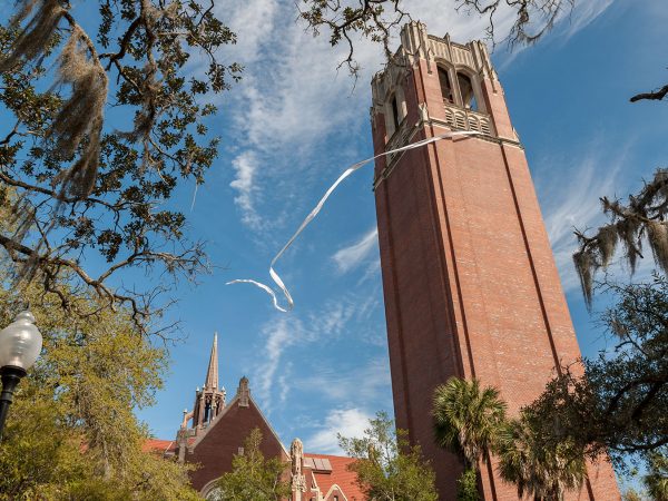 printed list of part of the tree of life hangs from the top of Century tower on the UF campus