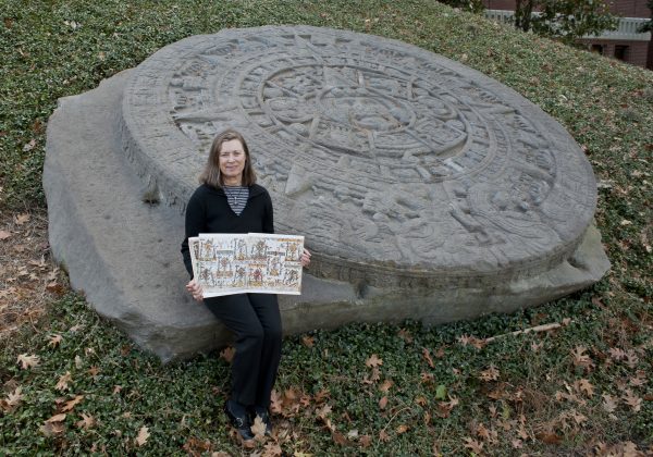 Susan Milbrath sits in front of Aztec stone