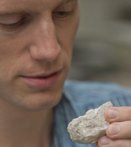 Researcher holds fossil crustacean