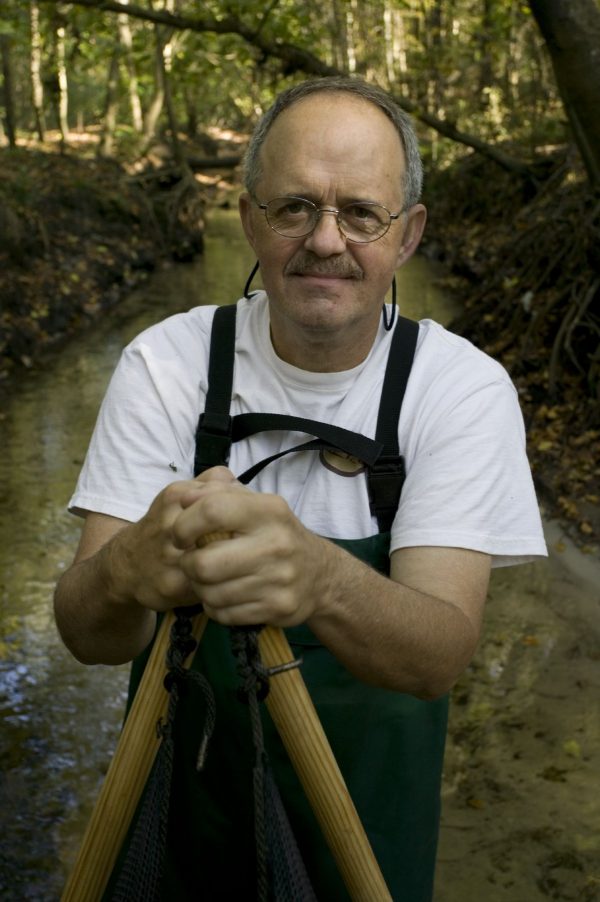 Larry in waders standing in creek