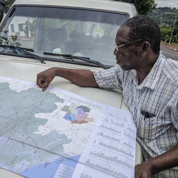 man looking at map on vehicle hood