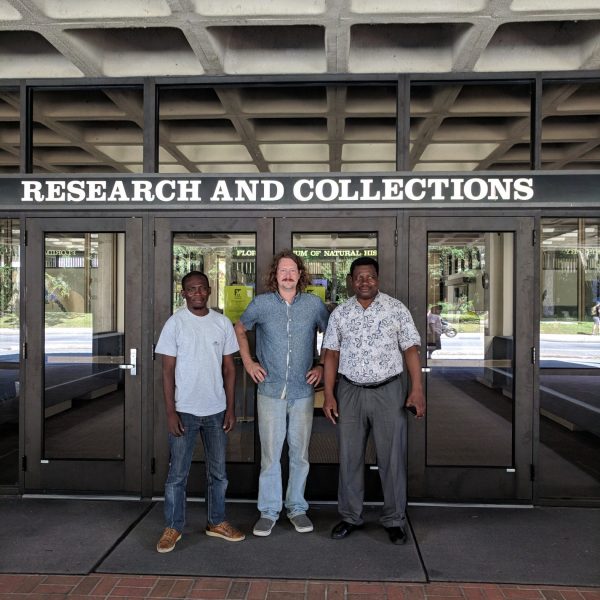 three men in front of museum entrance doors