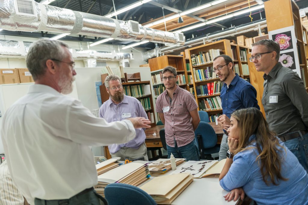 Mark talking to group of people in herbarium