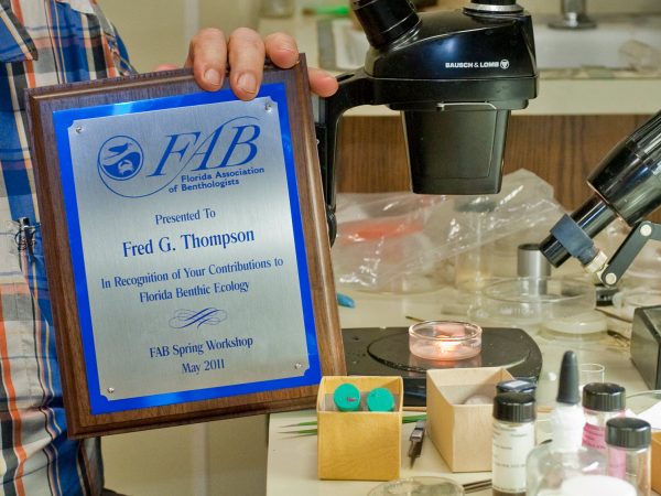 Fred holding award plaque in lab